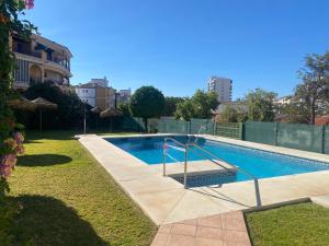 a swimming pool in a yard next to a building at Prealsa in Benalmádena