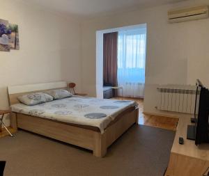 une chambre avec un grand lit et une grande fenêtre dans l'établissement Квартира в центрі в новобудові Набережний квартал, à Rivne