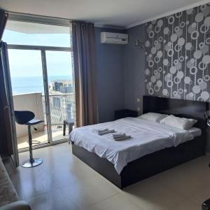 una camera con un grande letto e una grande finestra di ORBI BATUMi SEA VIEW a Batumi