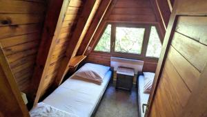an attic room with two beds and a window at VIVA SOLE domek nr 8 in Skorzęcin