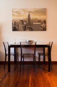 een eettafel met stoelen en een schilderij aan de muur bij Style Homes Brera San Marco 29 in Milaan