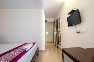 Zimmer mit einem Bett und einem TV an der Wand in der Unterkunft Hotel Pearl by Revgrow360 in Ranchi