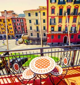 stół i krzesła na balkonie z budynkami w obiekcie Hotel Venezia w mieście La Spezia