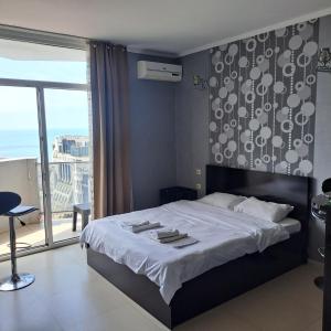 a bedroom with a large bed and a large window at ORBI BATUMi SEA VIEW in Batumi