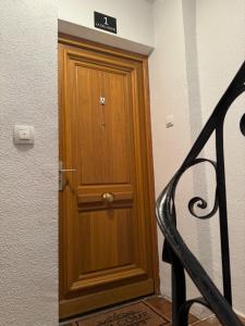 una puerta de madera con un cartel en la parte superior en La Sal Home Toledo, en Toledo