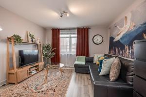 Una sala de estar con un sofá de cuero negro y un televisor. en Central Belfast Apartments: Citygate, en Belfast