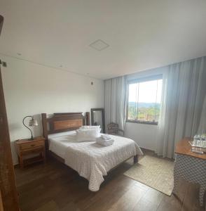 a bedroom with a bed and a window at Hotel Boutique Canto da Seriema in Tiradentes