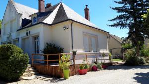 Biały dom z gankiem z doniczkami w obiekcie Gîte 3* Piscine Spa entre ZOO BEAUVAL FUTUROSCOPE CHATEAUX LOIRE w mieście Sainte-Maure-de-Touraine