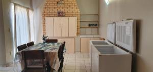 Una cocina con una mesa con sillas y un fregadero. en Victoria Court 2, en Henties Bay