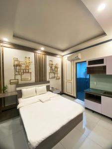 1 dormitorio con 1 cama blanca grande en una habitación en Khách Sạn Nhà Đất en Ấp Bình Hưng