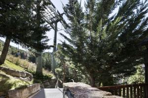 une passerelle avec un arbre et une tour dans l'établissement Luderna - Dúplex Cap de Aran A1, à Baqueira-Beret