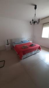 um quarto com uma cama vermelha num quarto branco em Casa di campagna pace e tranquillità em Brentanella
