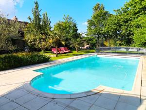een zwembad met blauw water in een tuin bij La Closerie DAUVILLIERS in Roinville