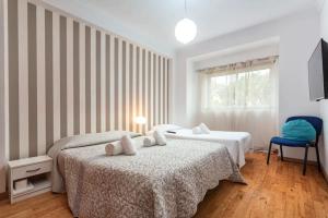 a bedroom with two beds and a blue chair at Blife Candya private rooms in Faro