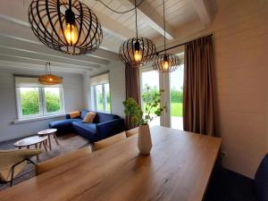 un salon avec une table et un canapé bleu dans l'établissement Groenendijk Verhuur Vakantiehuis Oud Brabers, à Burgh-Haamstede