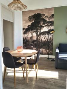 una sala da pranzo con tavolo, sedie e un dipinto di FAC 4 - Tram au pied l'immeuble- Parking free a Tolosa