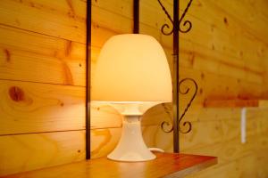 una lámpara blanca sentada sobre una mesa de madera en Tinyhaus 1 en Schöllnach