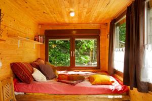 uma cama num chalé de madeira com uma janela em Tinyhaus 1 em Schöllnach