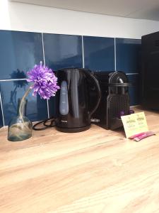 une fleur violette dans un vase à côté d'une cafetière dans l'établissement FAC 4 - Tram au pied l'immeuble- Parking free, à Toulouse