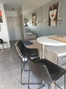 a living room with a table and two chairs at Studio Heliopolis Naturiste in Cap d'Agde