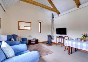 uma sala de estar com um sofá azul e uma mesa em Shippon em Walton West