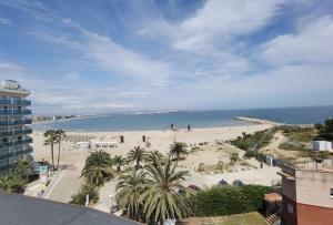 a view of a beach with palm trees and the ocean at Tu oasis, a la orilla del mar in Salou