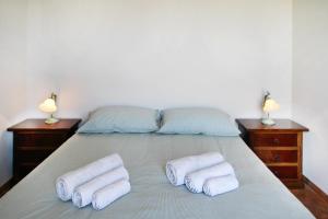 een slaapkamer met een bed met drie handdoeken erop bij Il giardino al mare di Anna in Caronia Marina