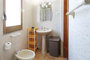 een badkamer met een wastafel, een toilet en een spiegel bij Il giardino al mare di Anna in Caronia Marina