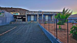 a house with a fence in front of it at جبل شمس Jabal Shams sunset House in Dār Sawdāʼ