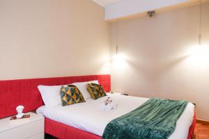 una camera da letto con un letto rosso con una bambola seduta sopra di Loft Foscolo Open Space a Torino