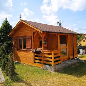 drewniany domek z dachem na polu trawiastym w obiekcie NOCLEGI KAMEX domek 2-osobowy w mieście Olsztyn