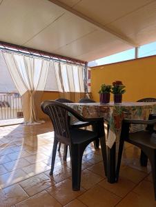 een eetkamer met een tafel en stoelen en een balkon bij La casa di Andrea in Terrasini