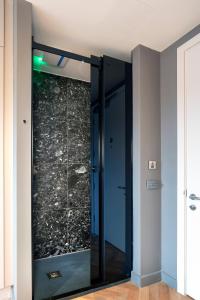 un ascenseur en verre dans une chambre avec un mur en pierre dans l'établissement Niche Living - Dun Laoghaire, à Dublin