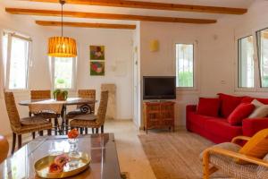ein Wohnzimmer mit einem roten Sofa und einem Tisch in der Unterkunft Oliva Nova Villa Mar in Oliva