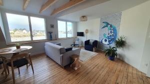 uma sala de estar com um sofá e uma mesa em Sur le Port de Plaisance - Anatoline Appart'Hotel em Audierne