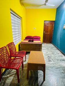 a room with a bed and two chairs and a table at Night Space hostel in Kalpetta