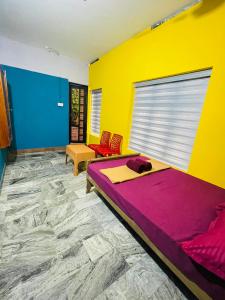 1 dormitorio con 1 cama y pared amarilla y azul en Night Space hostel en Kalpetta
