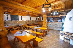 una sala da pranzo con tavoli in legno in un ristorante di Penzion Oravsky Zrub a Nižná