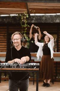 un hombre sentado en una mesa con un teclado en The Tree House Tenerife, en El Médano