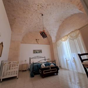 洛科羅通的住宿－Trulli di Rosa，一间卧室设有一张床和一个大窗户