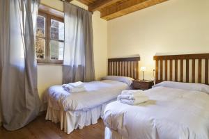 een slaapkamer met 2 bedden en handdoeken bij Luderna - Apartamento Orri A1 in Gessa