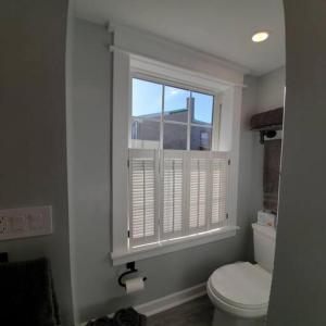 a bathroom with a toilet and a window at Fun Fishtown Rowhome - Sleeps 4 in Philadelphia