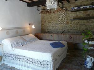 a bedroom with a white bed in a brick wall at Podere Del Fagiano in Tolentino