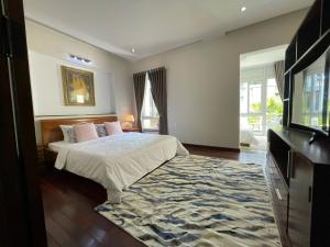 a bedroom with a bed and a flat screen tv at Moon Homestay Huế in Thôn Dương Xuân Hạ
