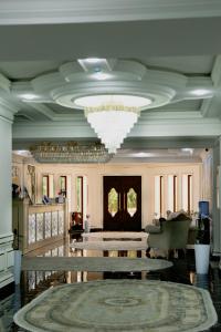 Cette grande chambre dispose de tables et d'un lustre. dans l'établissement Ko'k Saroy Plaza Hotel, à Samarcande