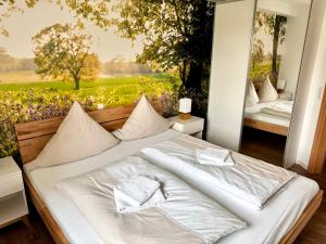 a white bed in a room with a painting at Ferienhof Wübbold - Sommerflieder in Rieste