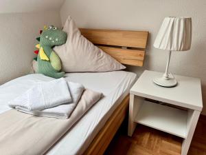 a bed with a stuffed dinosaur sitting on top of it at Ferienhof Wübbold - Lavendel in Rieste +7 photos