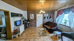 a living room with a couch and a television at Meiks Ferienwohnung in Erfde