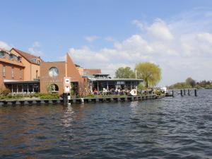 a restaurant on a dock next to a body of water at Ferienwohnung-Sonnenterrasse in Malchow