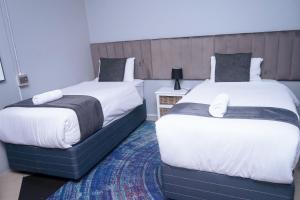 dwa łóżka siedzące obok siebie w sypialni w obiekcie Safi Suites and Conference Centre w mieście Mthatha